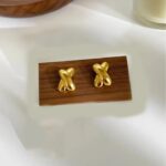 sway stud earrings on a wooden block